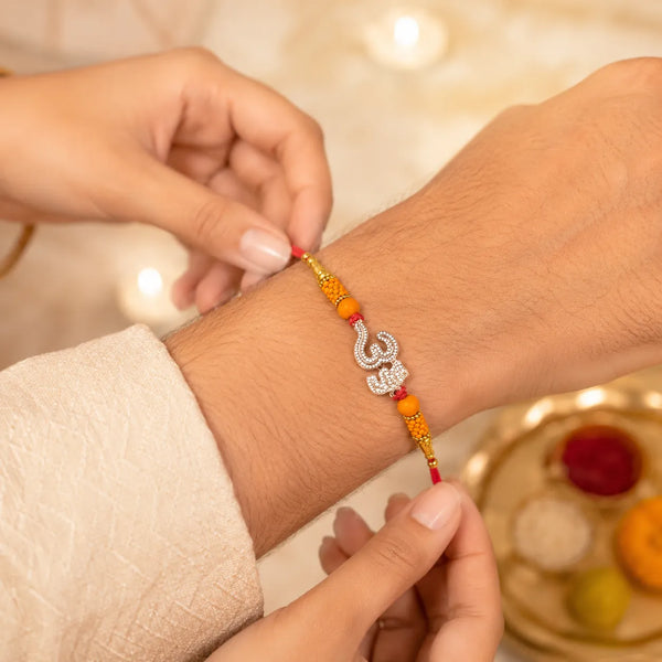 Crystal Om Silver Rakhi with Orange Beads