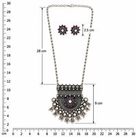 Silver-toned statement necklace with a matching pair of stud earrings, featuring a detailed filigree pendant with a central floral motif in purple, green, and white on a pale pink background.